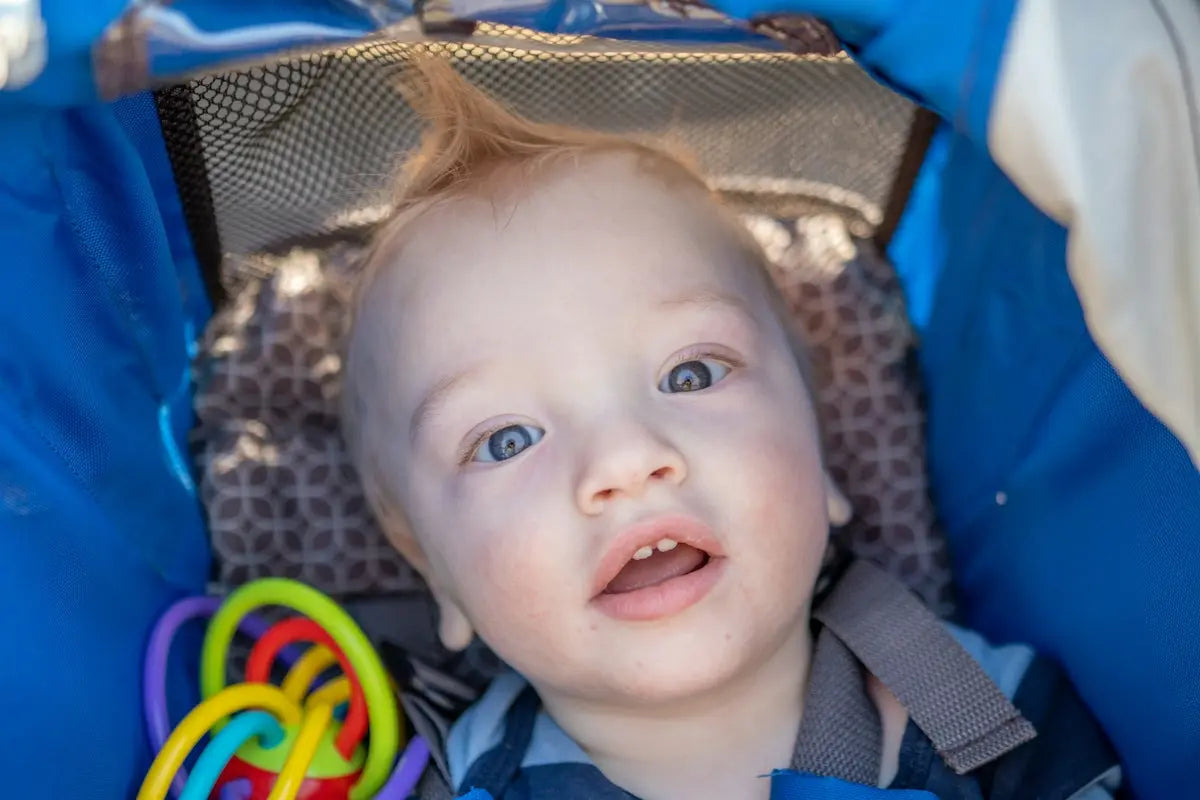 a baby in a stroller looking up at the camera