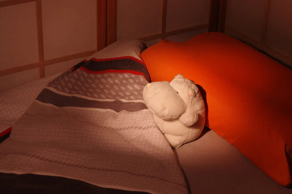 a stuffed animal laying on top of a bed